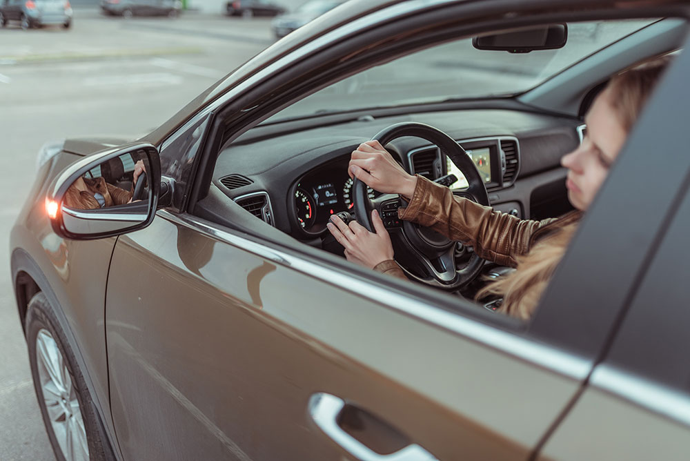 woman making an unsafe turn in brown car